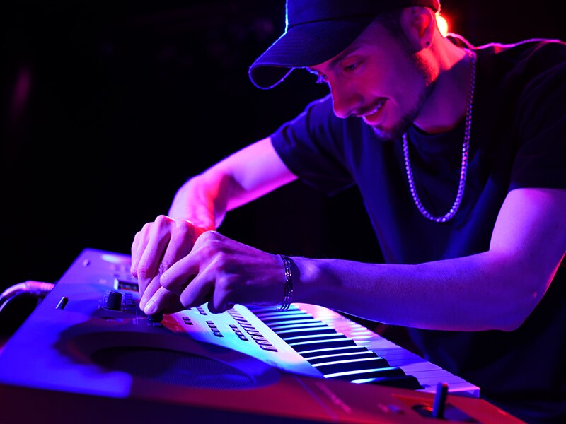 Performer adjusting the Live Control Knobs on a PSR-SX620 during a live performance.