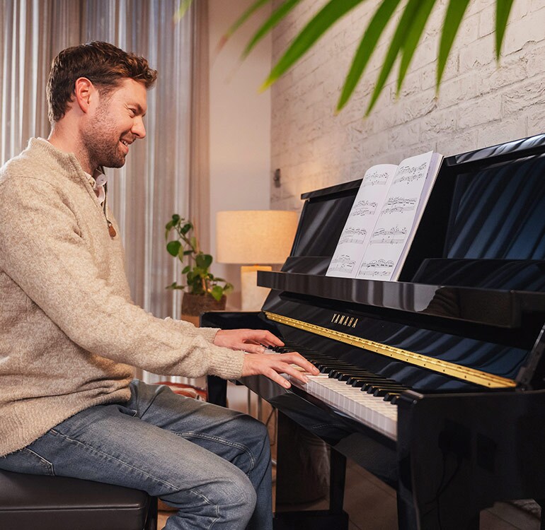 A woman enjoys playing the B Series upright piano
