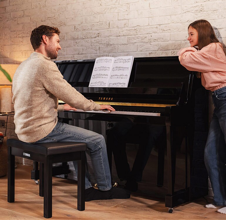 A mother and daughter enjoy playing the B Series upright piano