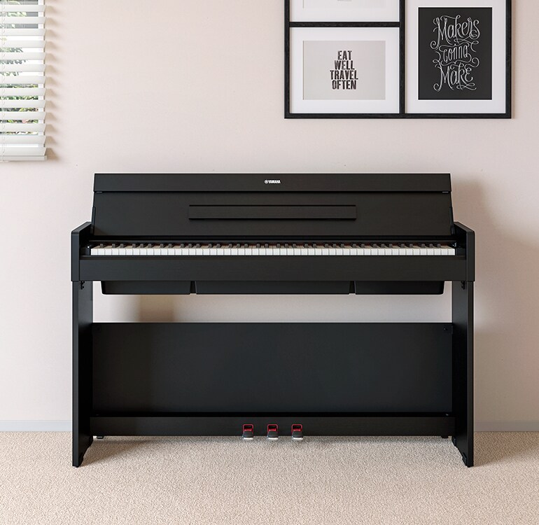 A living room featuring a black ARIUS piano positioned next to wall shelves with lamps and a diffuser, blending harmoniously with the interior.
