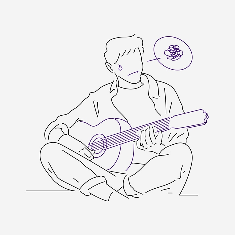 A man having difficulty practising the guitar